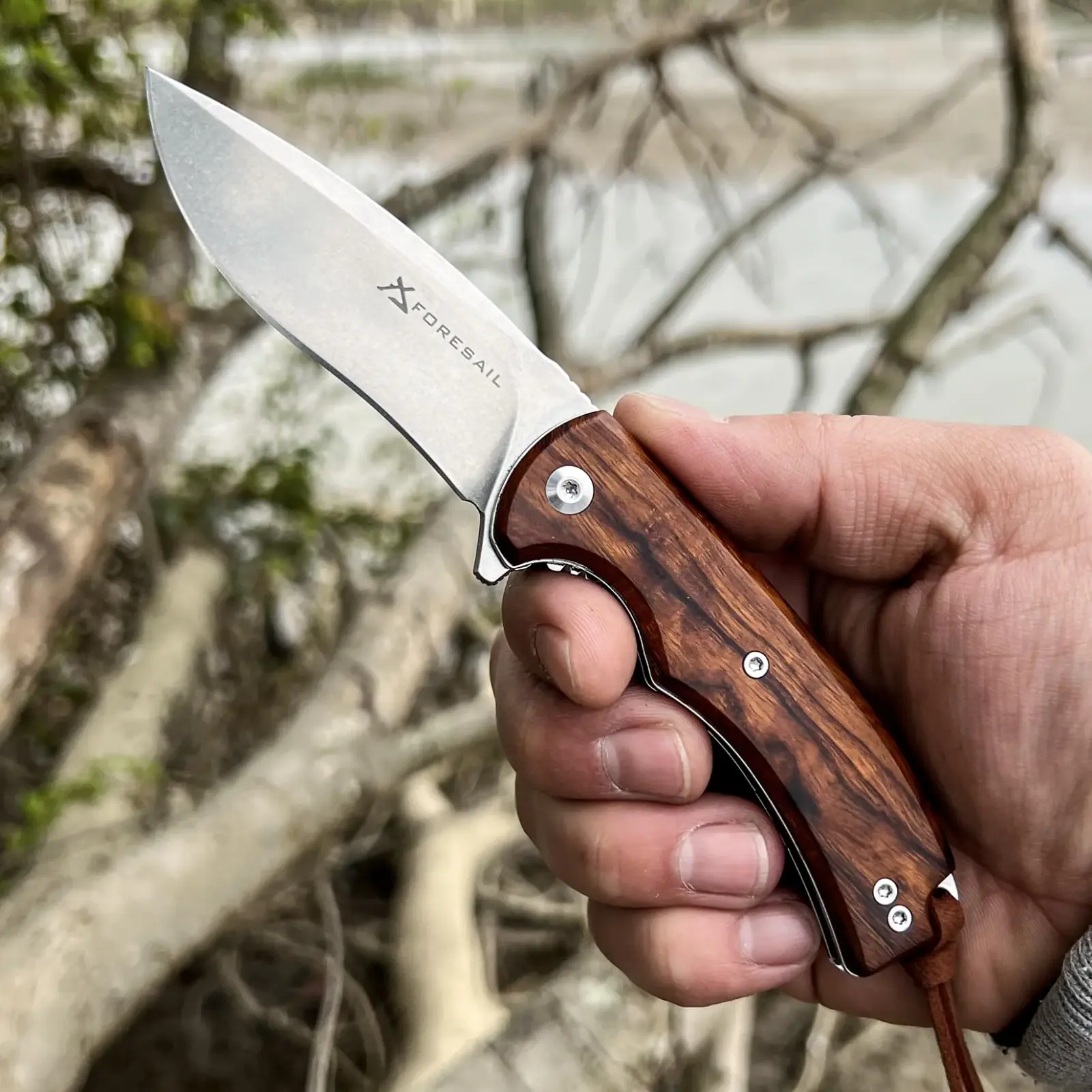 FORESAIL folding knife with a Desert Ironwood handle shown outdoors